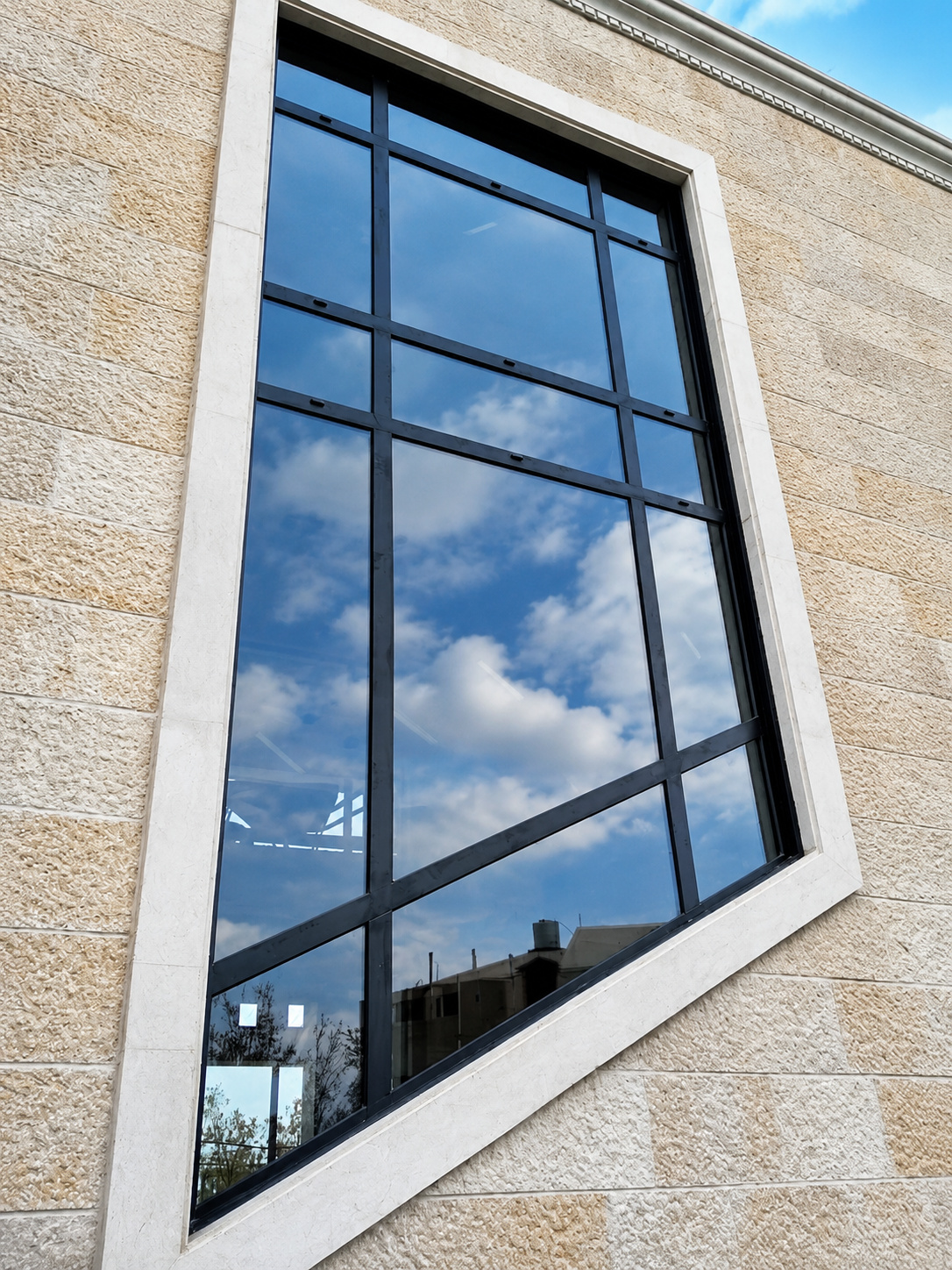 Custom angled feature window in a stone building.
